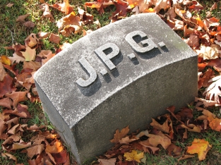 imagen de una lápida con las siglas JPG